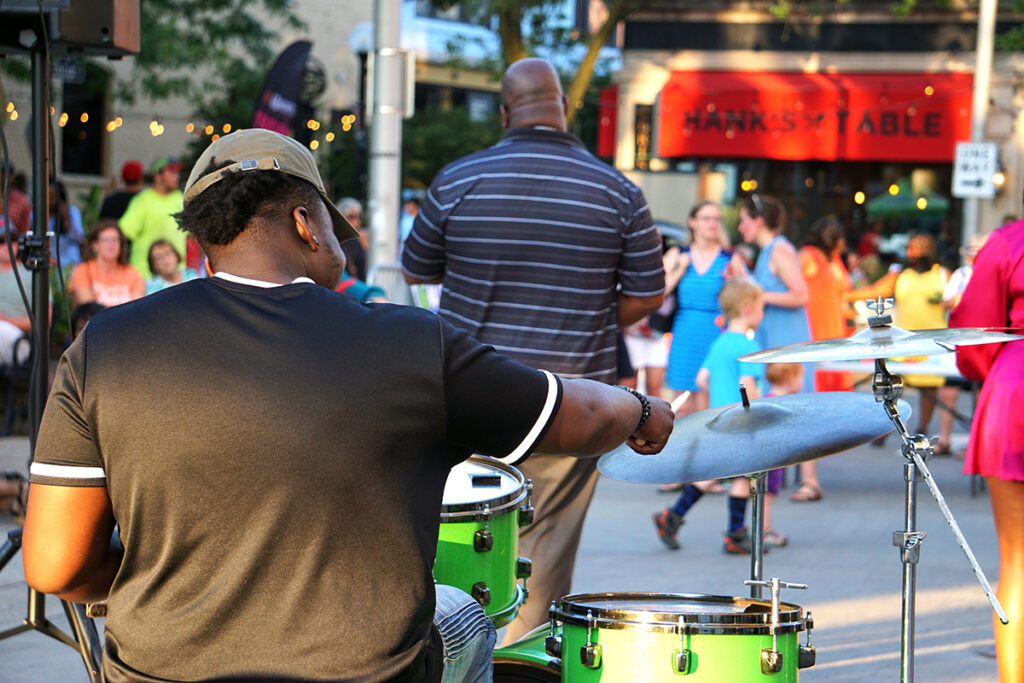 Man using a drum set at an outdoor concert